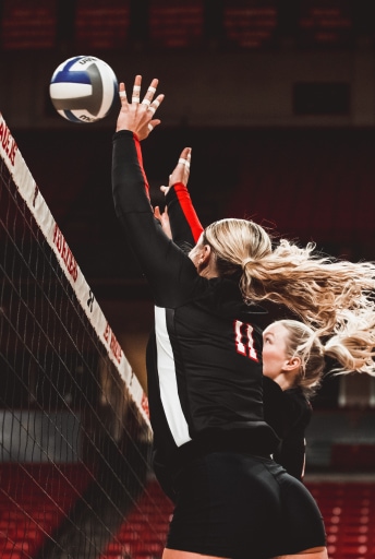 Women's Volleyball players blocking at the net