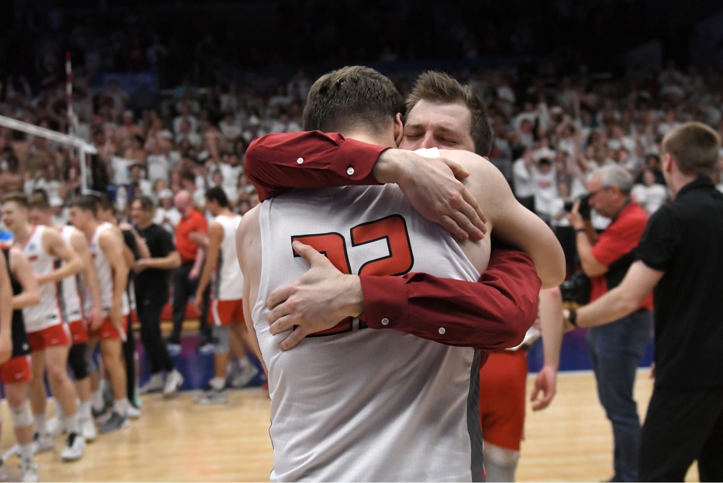 M79 1 Men's volleyball coach embracing one of his athletes after a match