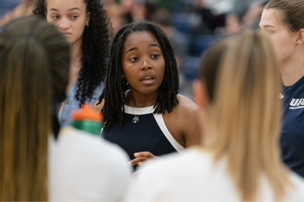 W250 1 volleyball coach providing feedback to athletes in the huddle